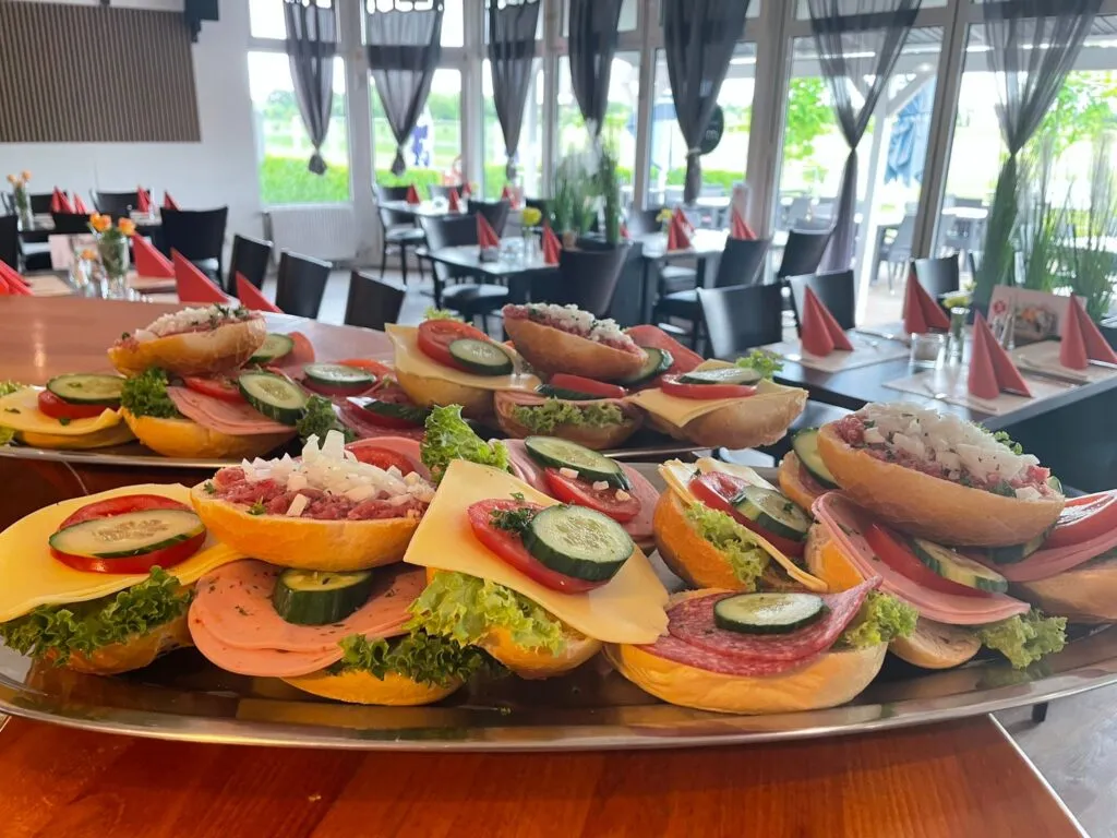 Belegte Brötchenplatte mit Wurst, Käse und frischem Gemüse