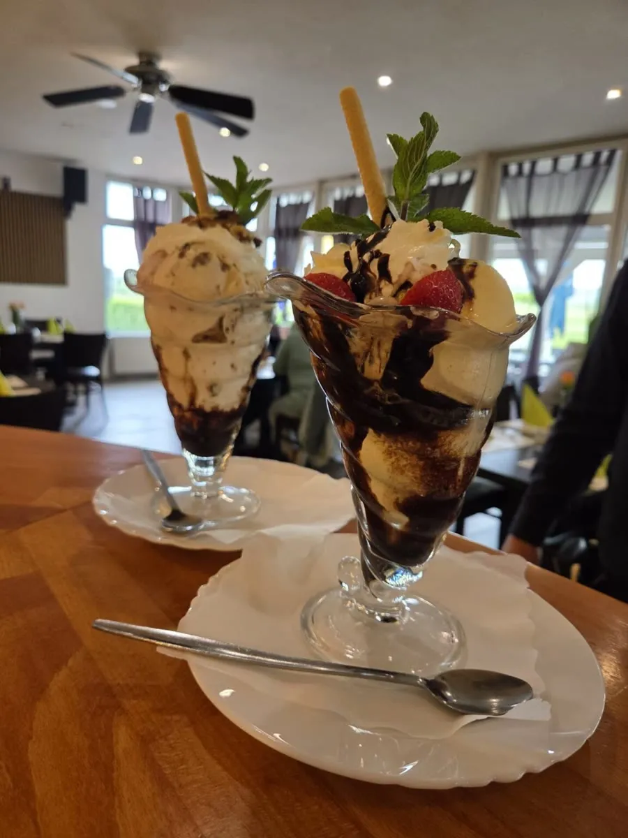 Schokoladen-Eisbecher mit Sahne, Erdbeeren und Minze
