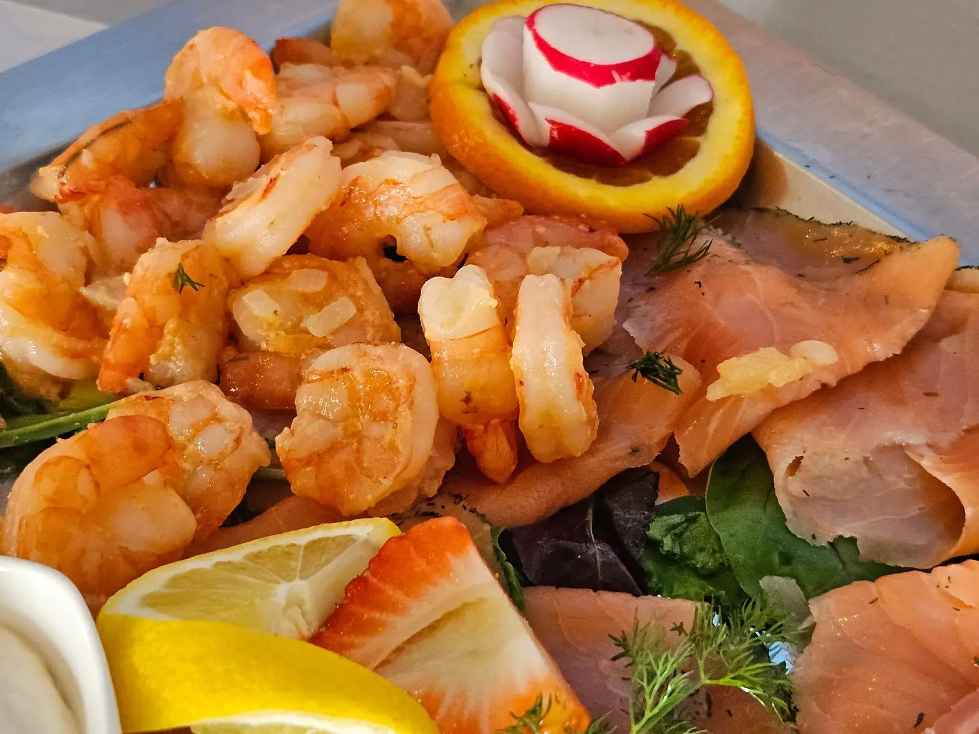 Garnelen und Räucherlachs auf einer Fischplatte mit Zitrone