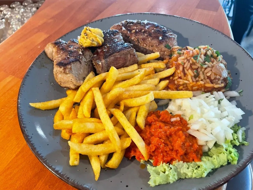 Grillteller mit Steak, Pommes, Djuvec-Reis und Ajvar